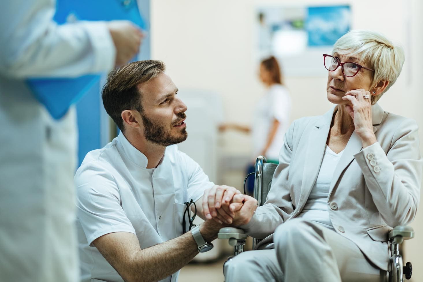 Doctor talking to a concerned mature woman in wheelchair at the